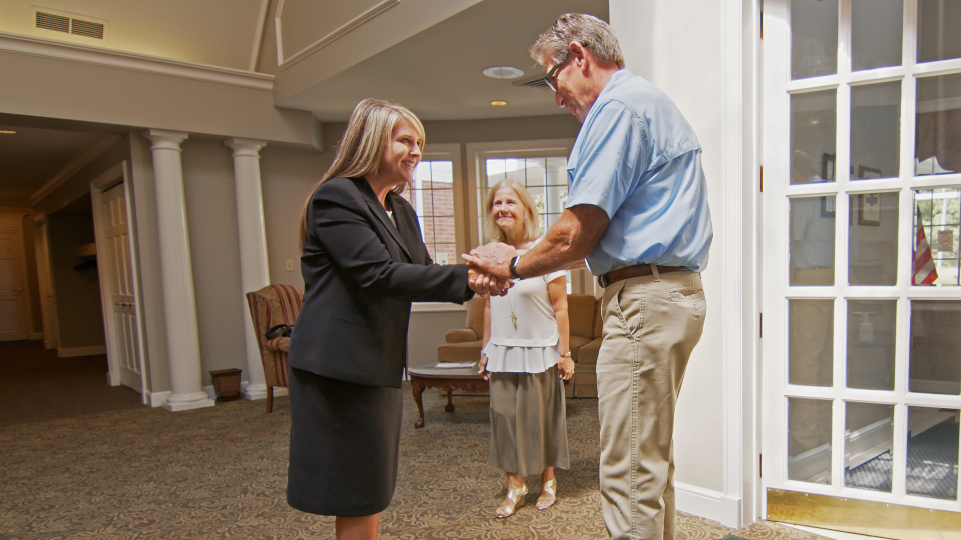 A group of people are standing around a urn at a funeral.