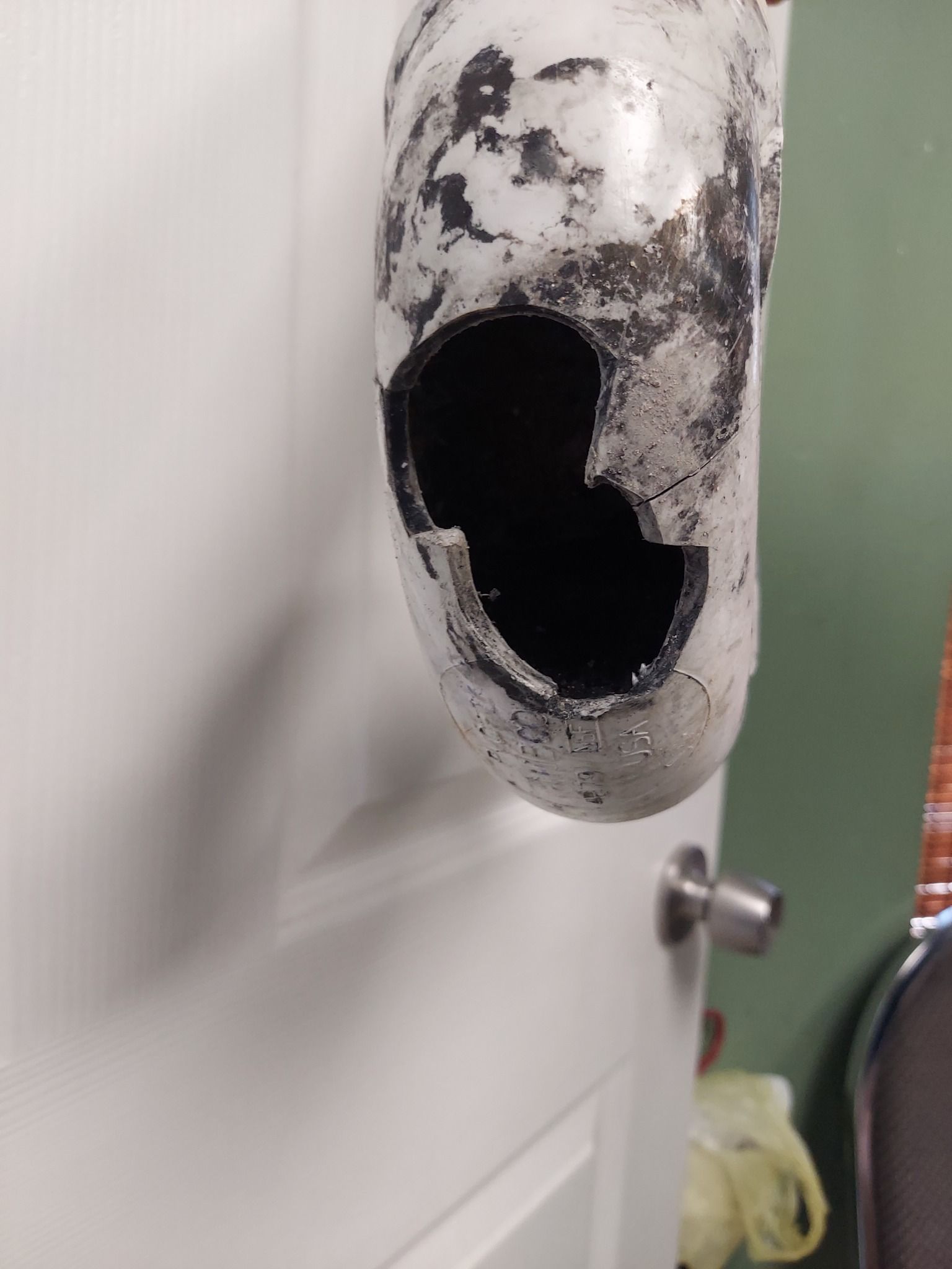 A white object with a hole in it is hanging on a door.