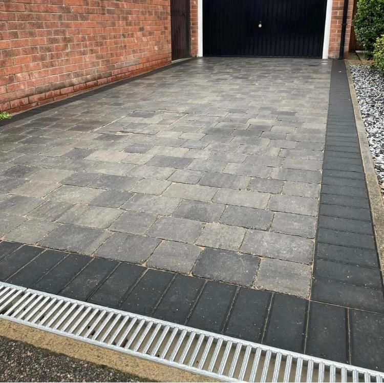 Grey and black block paving in square shapes.