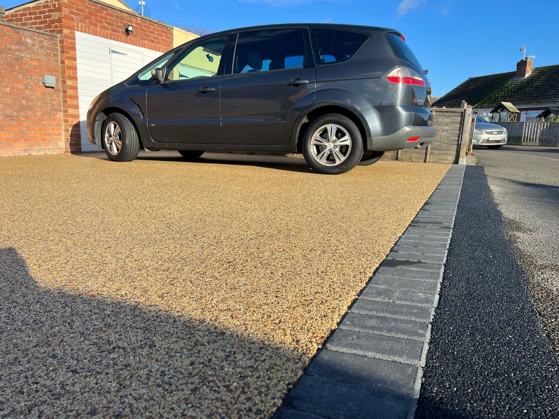 Gold resin driveway with black charcoal block borders.