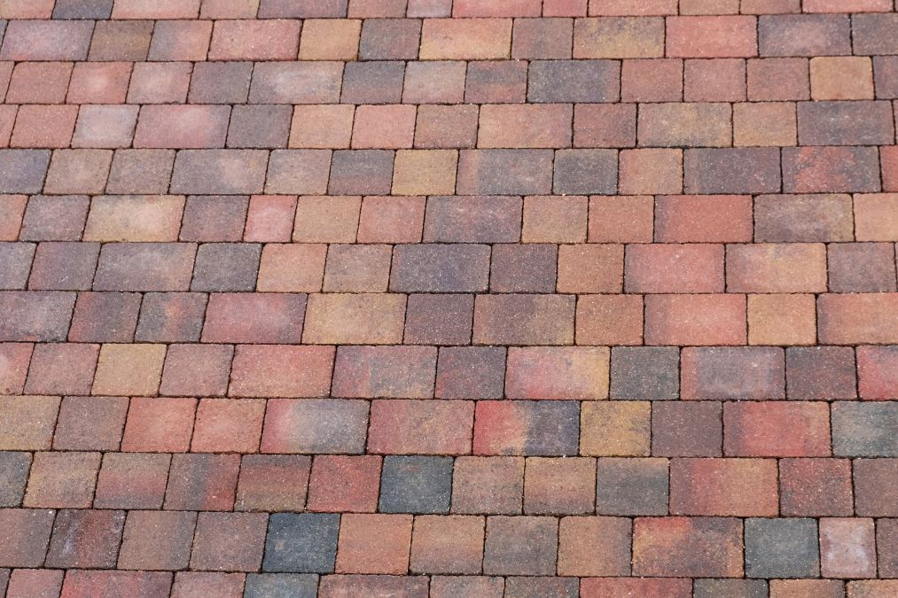 Red, orange, and light brown block pavers for a driveway installation.