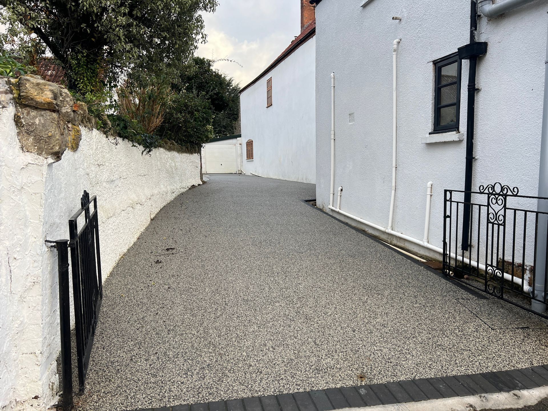 A gravel driveway leading to a white building