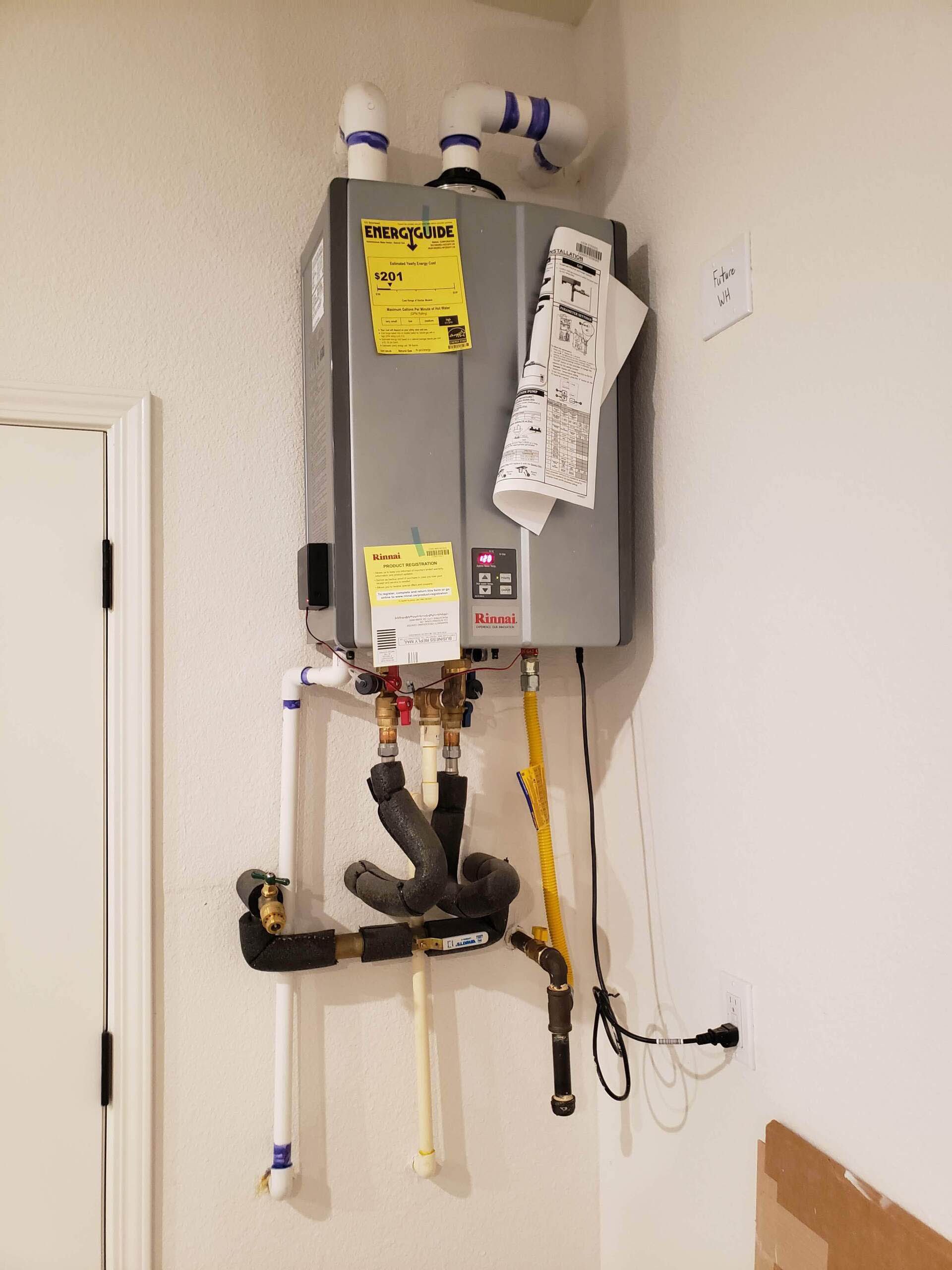 A water heater is hanging on a wall in a room.