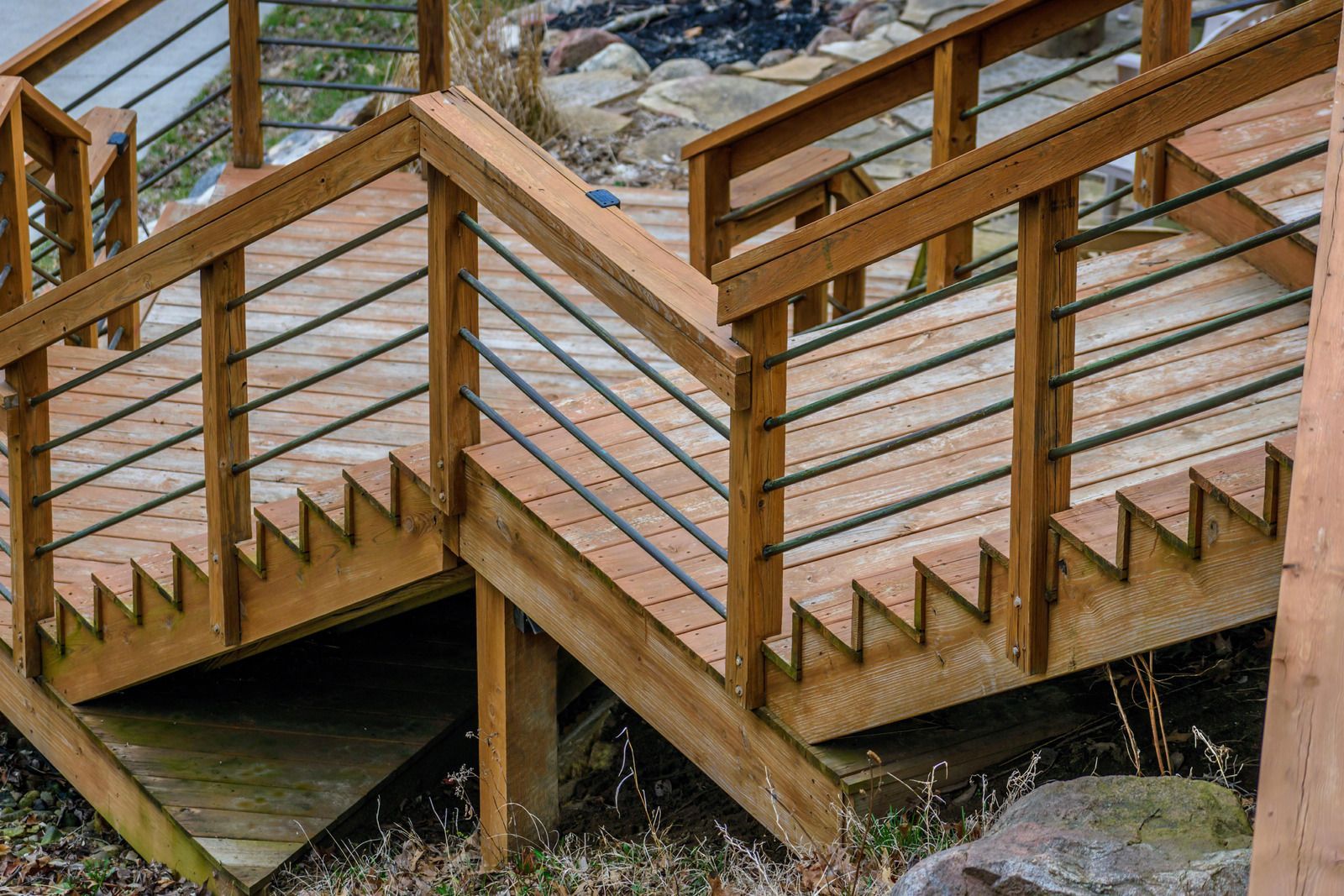 A wooden deck with stairs and a metal railing.