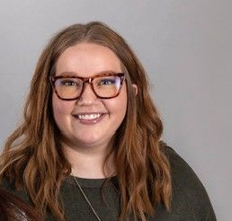 A silhouette of a person without a face on a gray background.