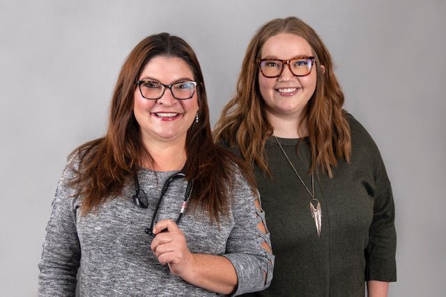 Two women wearing glasses and a stethoscope are standing next to each other.