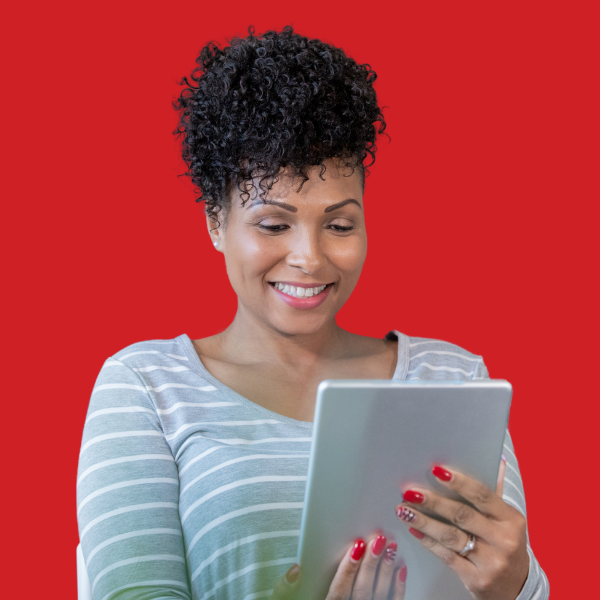 A woman is using a tablet computer on a red background.