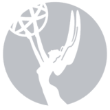 Emmy Award statuette: a winged woman holding an atom, set in a gray circle.