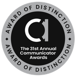 Award of Distinction badge from the Communicator Awards. Silver border surrounds a black circle with a white
