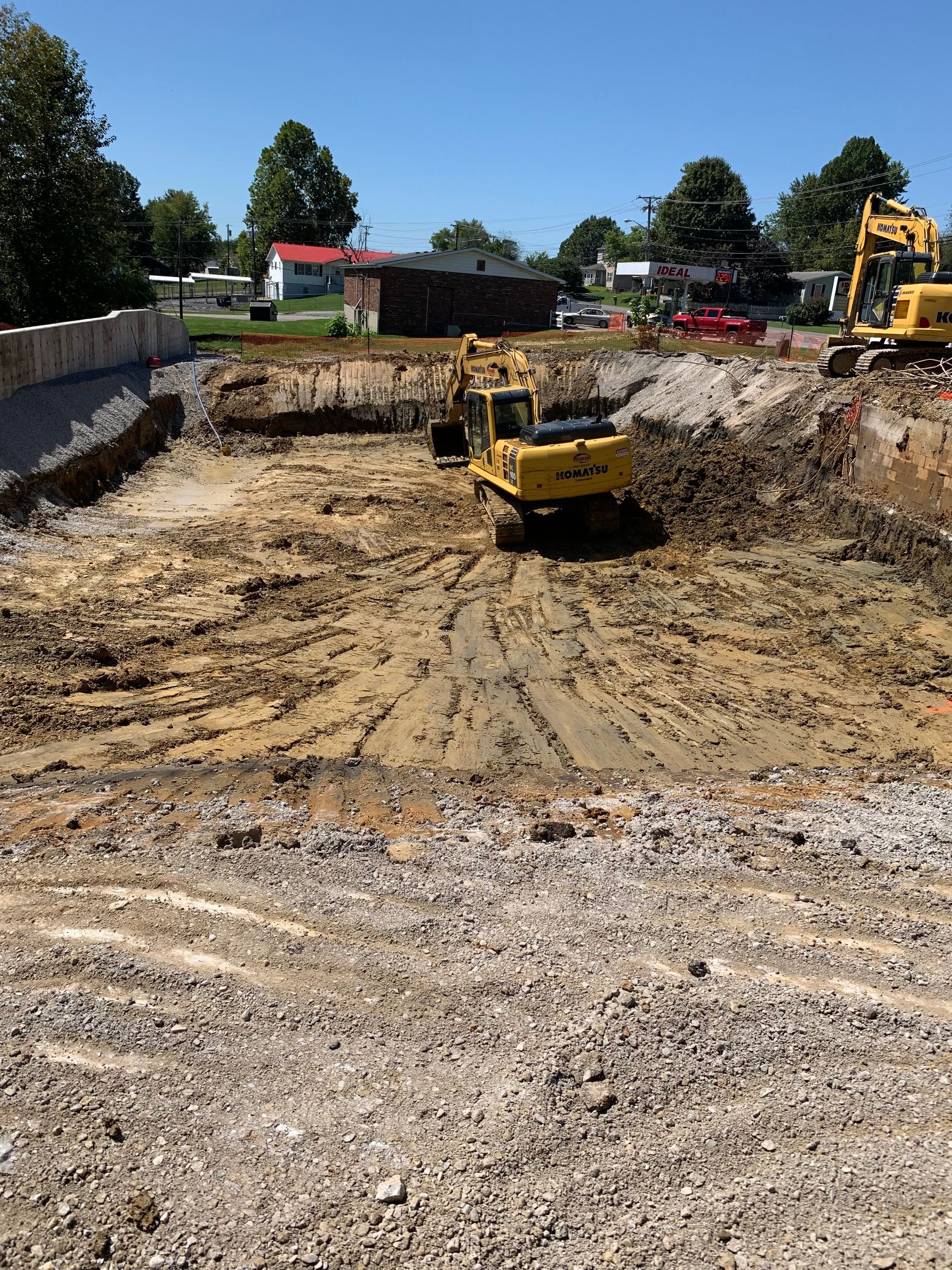 Excavator Unloading Into A Dumper Truck — Madisonville, KY — Steve Pleasant Excavating & Hauling