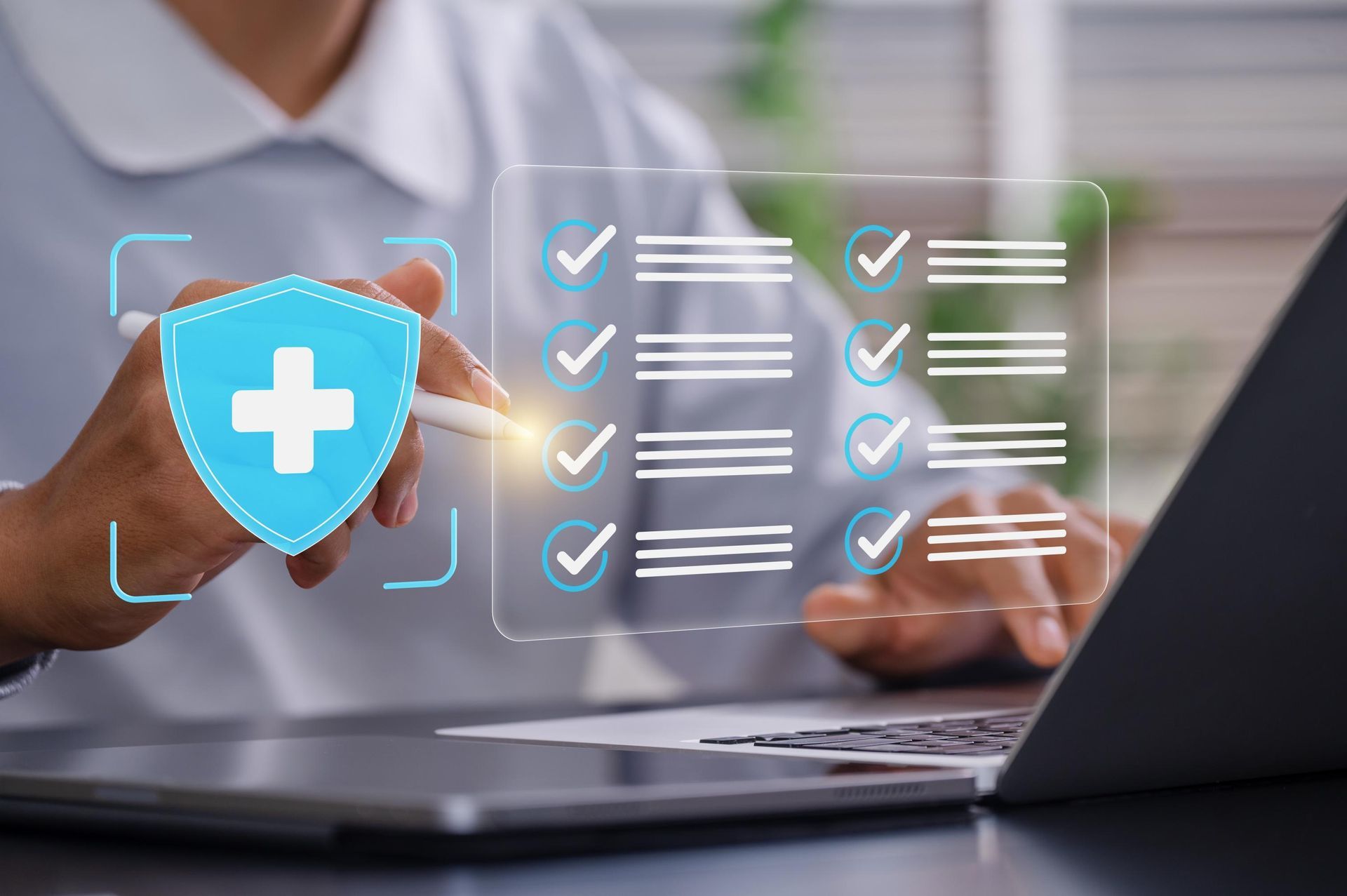 Hands using a laptop with a blue shield icon and checklist overlay, suggesting online security or compliance