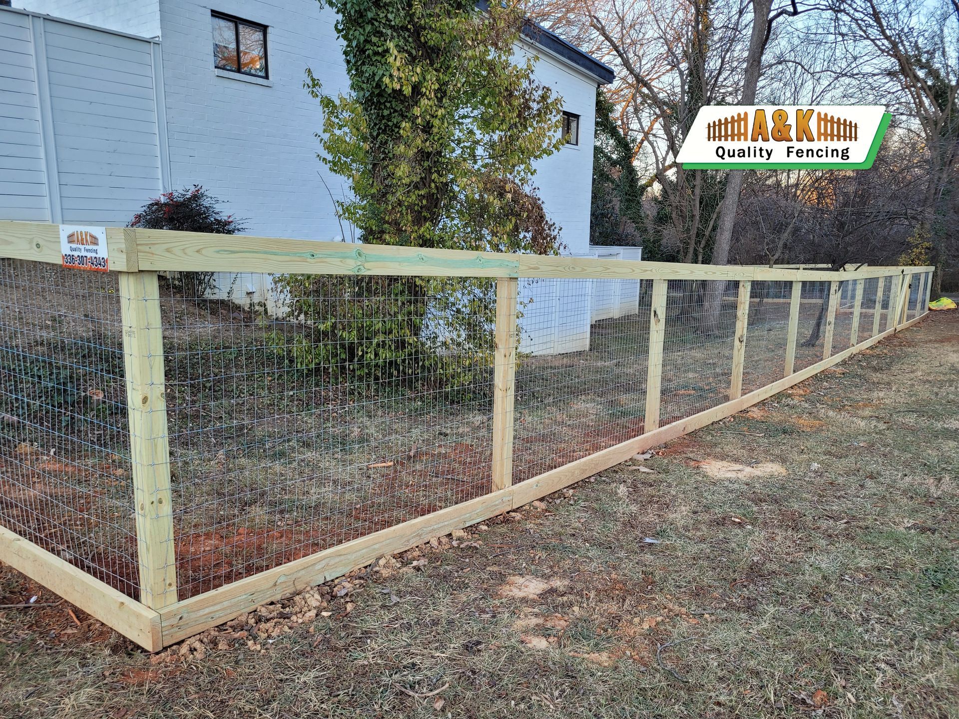 A wooden fence is being built in front of a house.