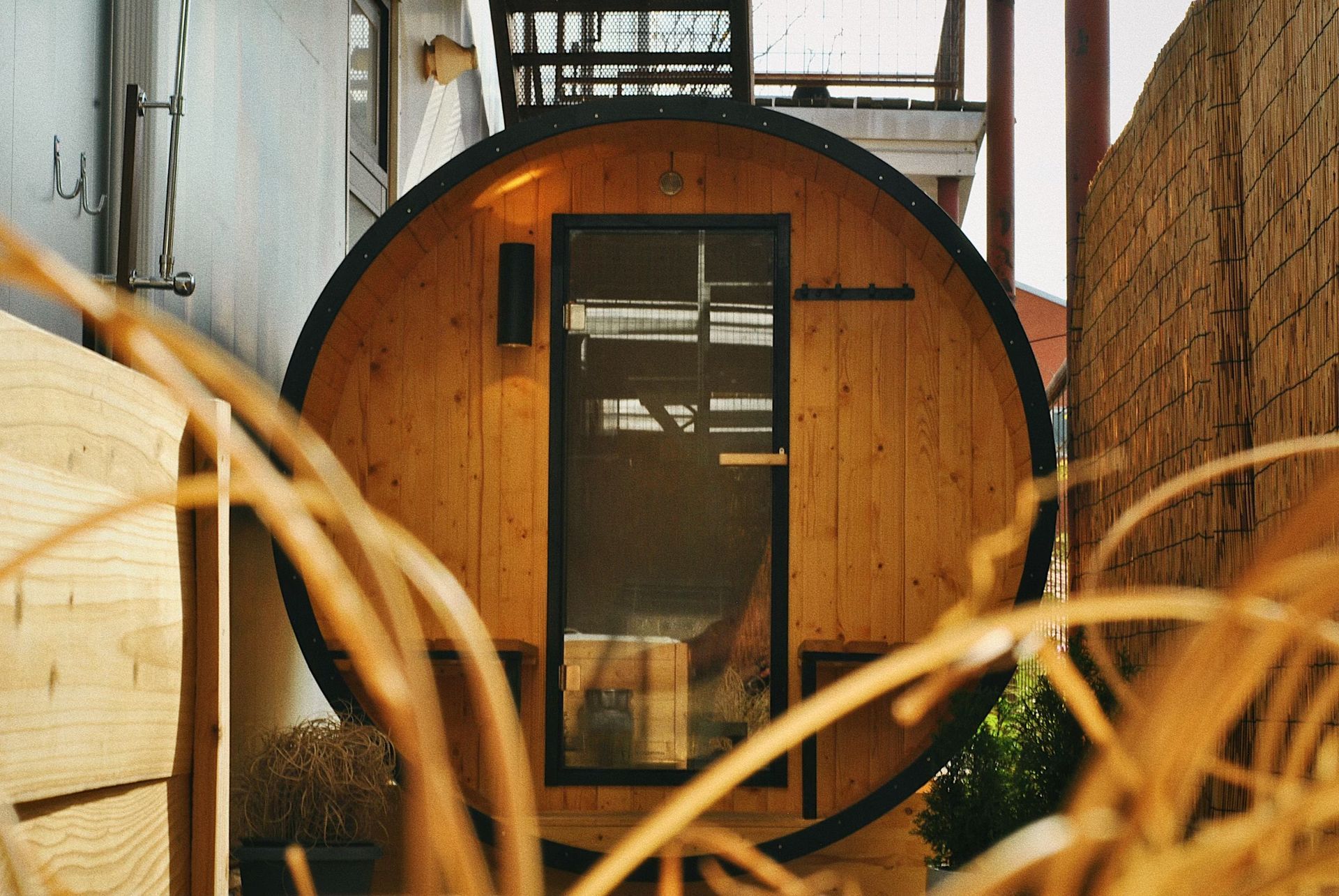 A wooden barrel with a glass door is sitting next to a brick wall.