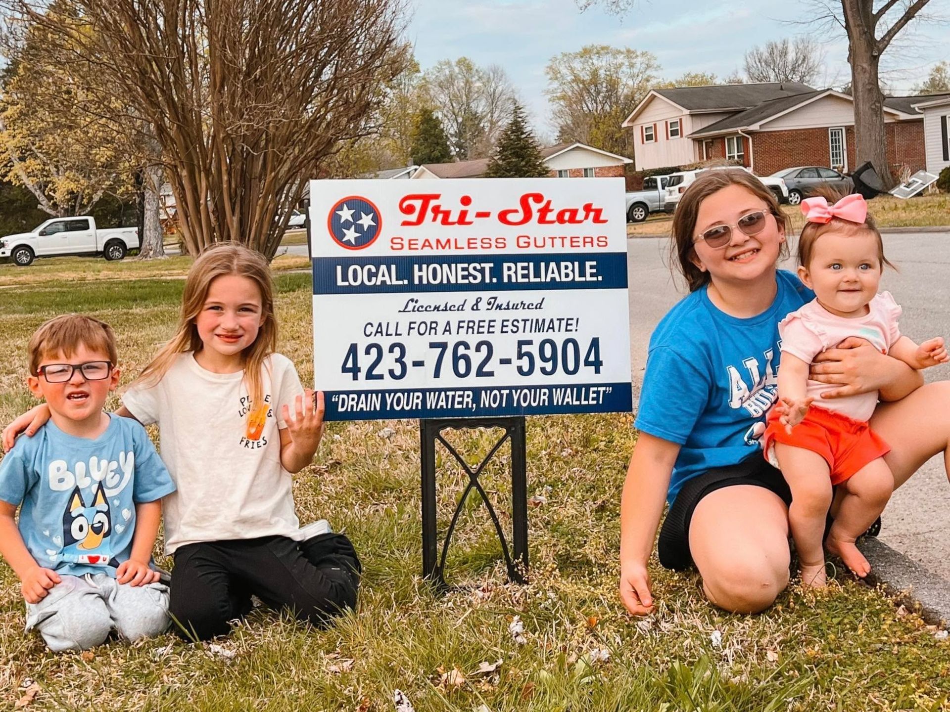 Children posing with a sign that says 