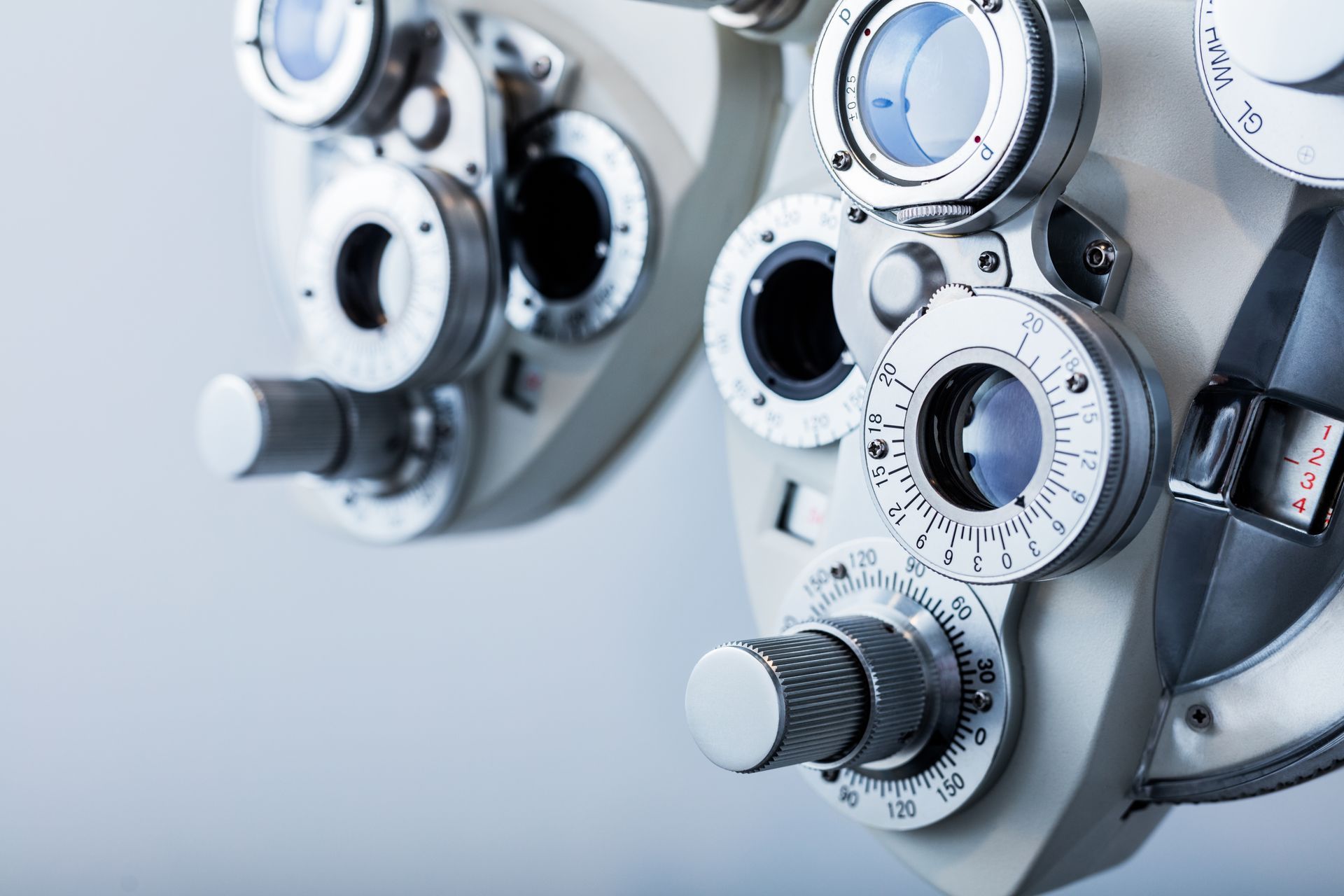 Close-up of a phoropter with circular lens dials used for an eye exam