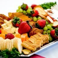 Fruit and cheese platter with strawberries, grapes, crackers, and sliced cheese on a tray