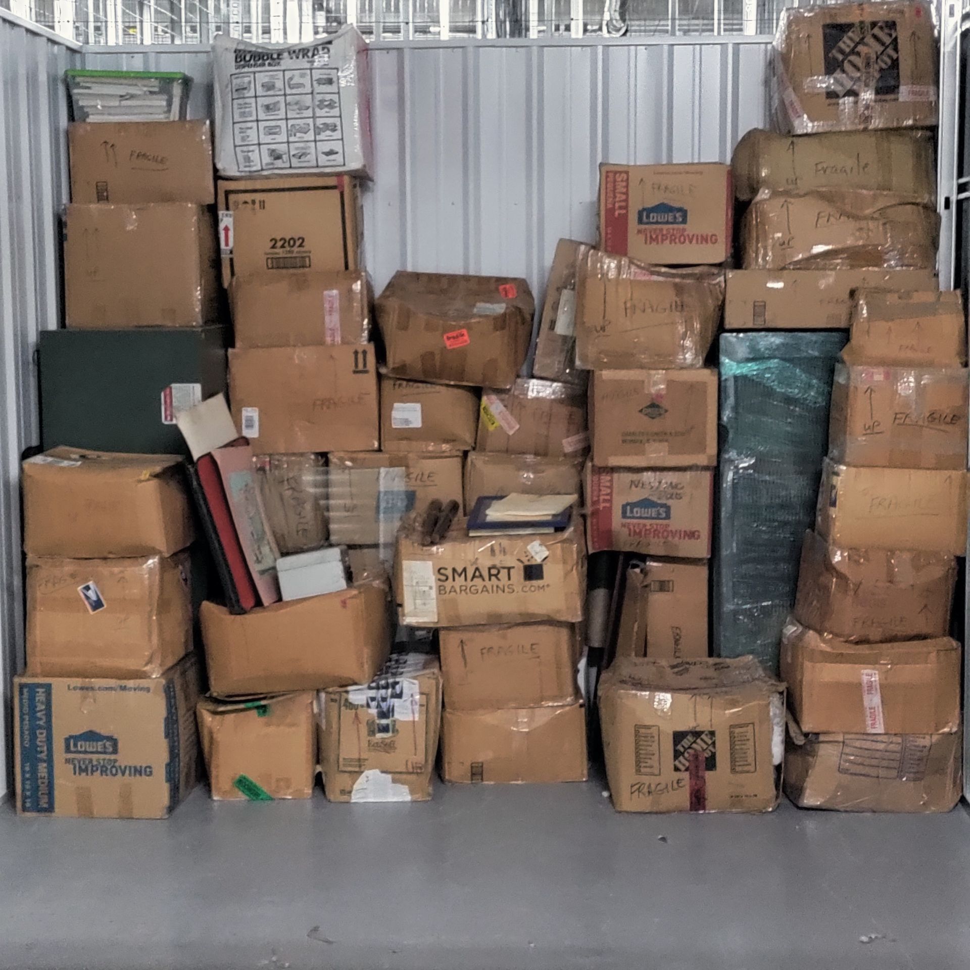Storage unit packed with numerous cardboard boxes of various sizes.