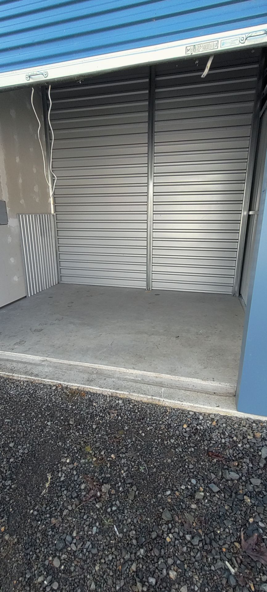 Empty storage unit with an open metal door.