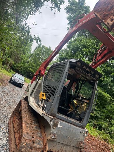 A bulldozer is sitting on the side of a dirt road.