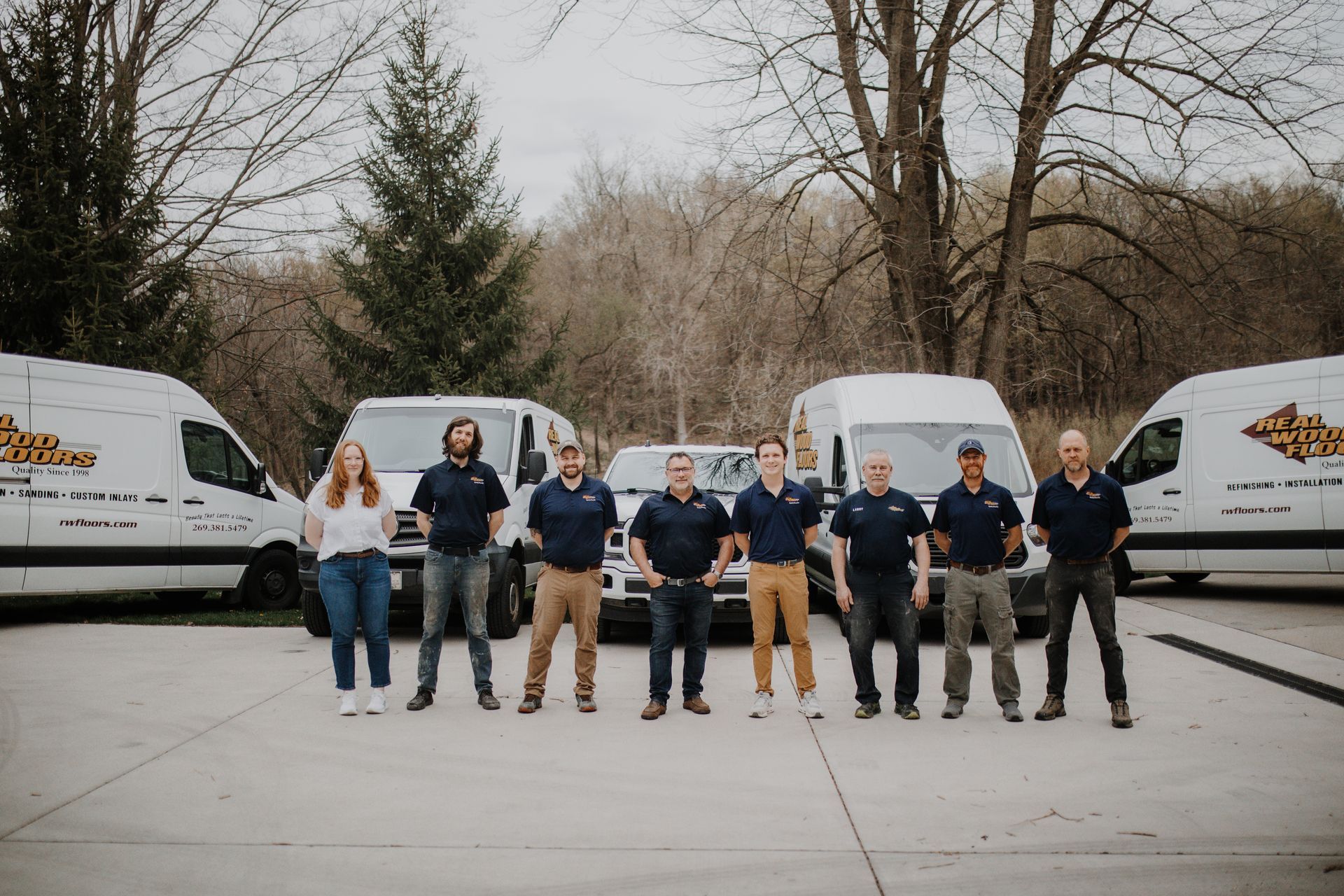 A group of people standing in front of a row of vans.