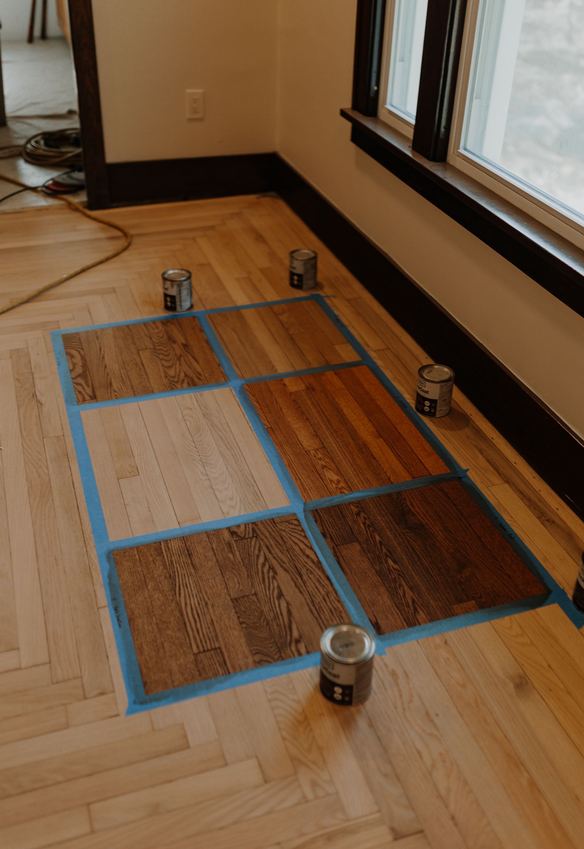 A wooden floor is being painted in a room.