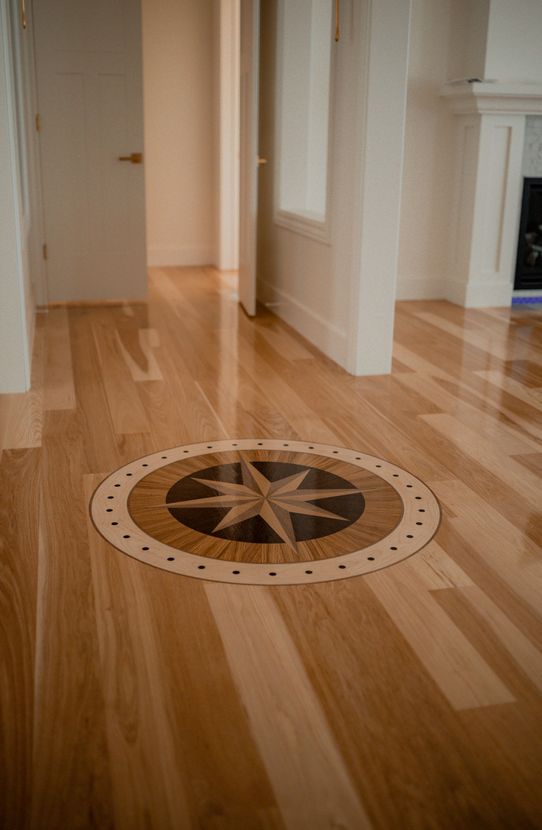 A wooden floor with a compass in the middle of it.