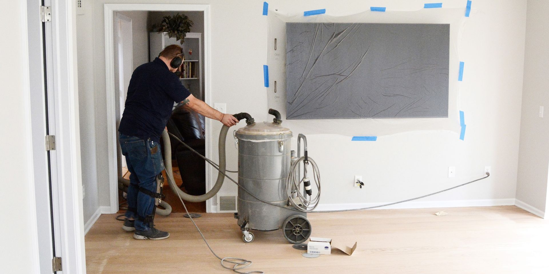 A man is using a vacuum cleaner to clean a room.