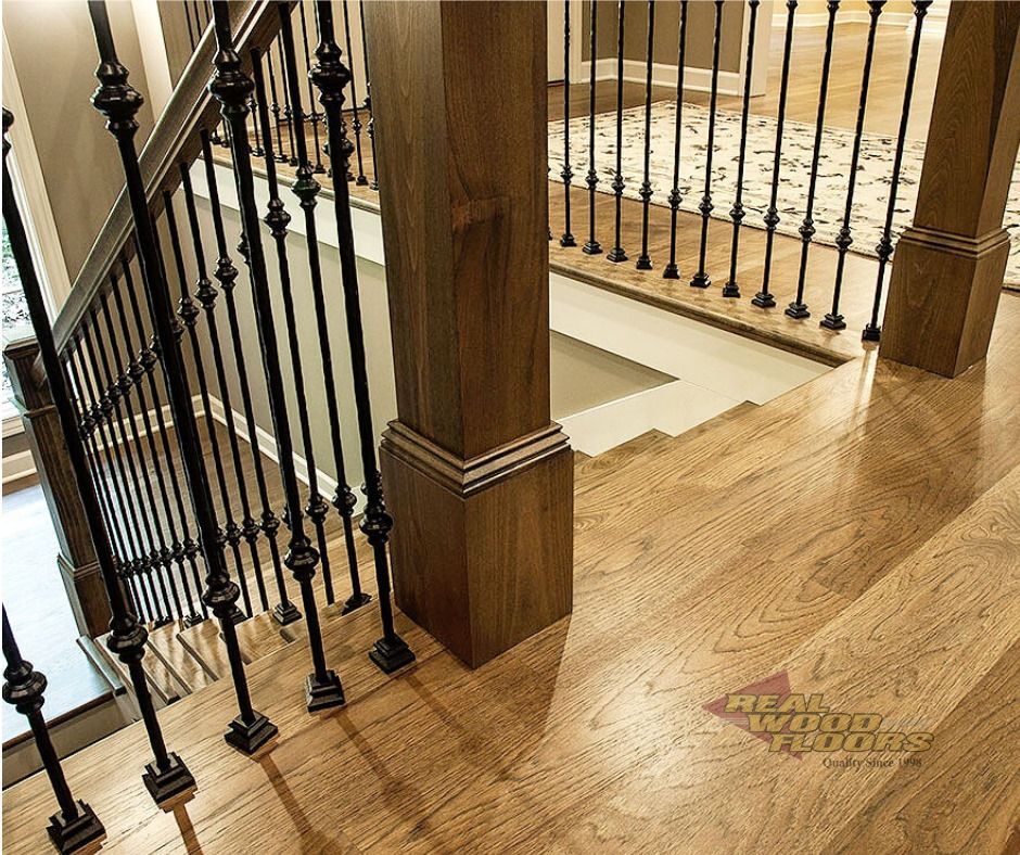 A picture of a wooden staircase with a metal railing