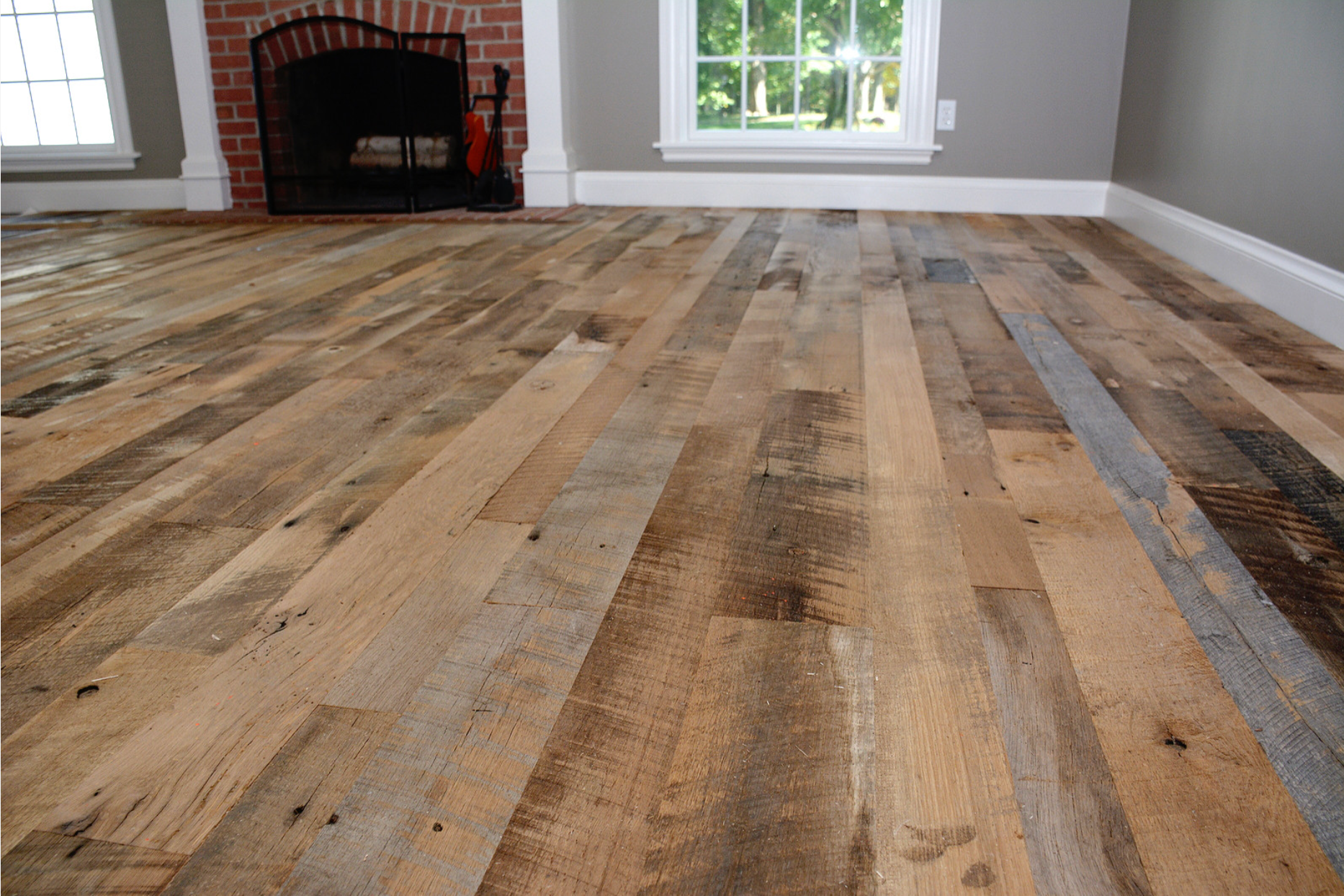 A living room with a wooden floor and a fireplace.