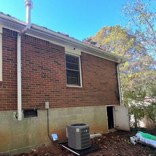 A brick house with an air conditioner on the side of it.