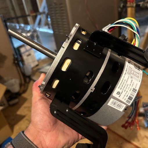 A person is holding a fan motor in their hand