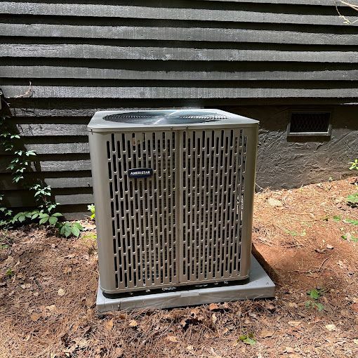 An air conditioner is sitting in the dirt in front of a house.