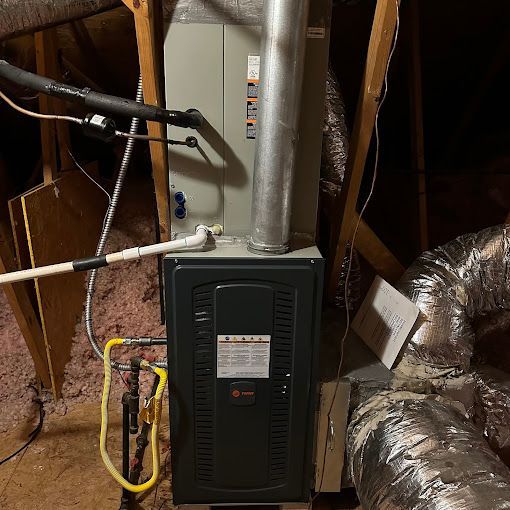 An air conditioner is sitting in the attic of a house.