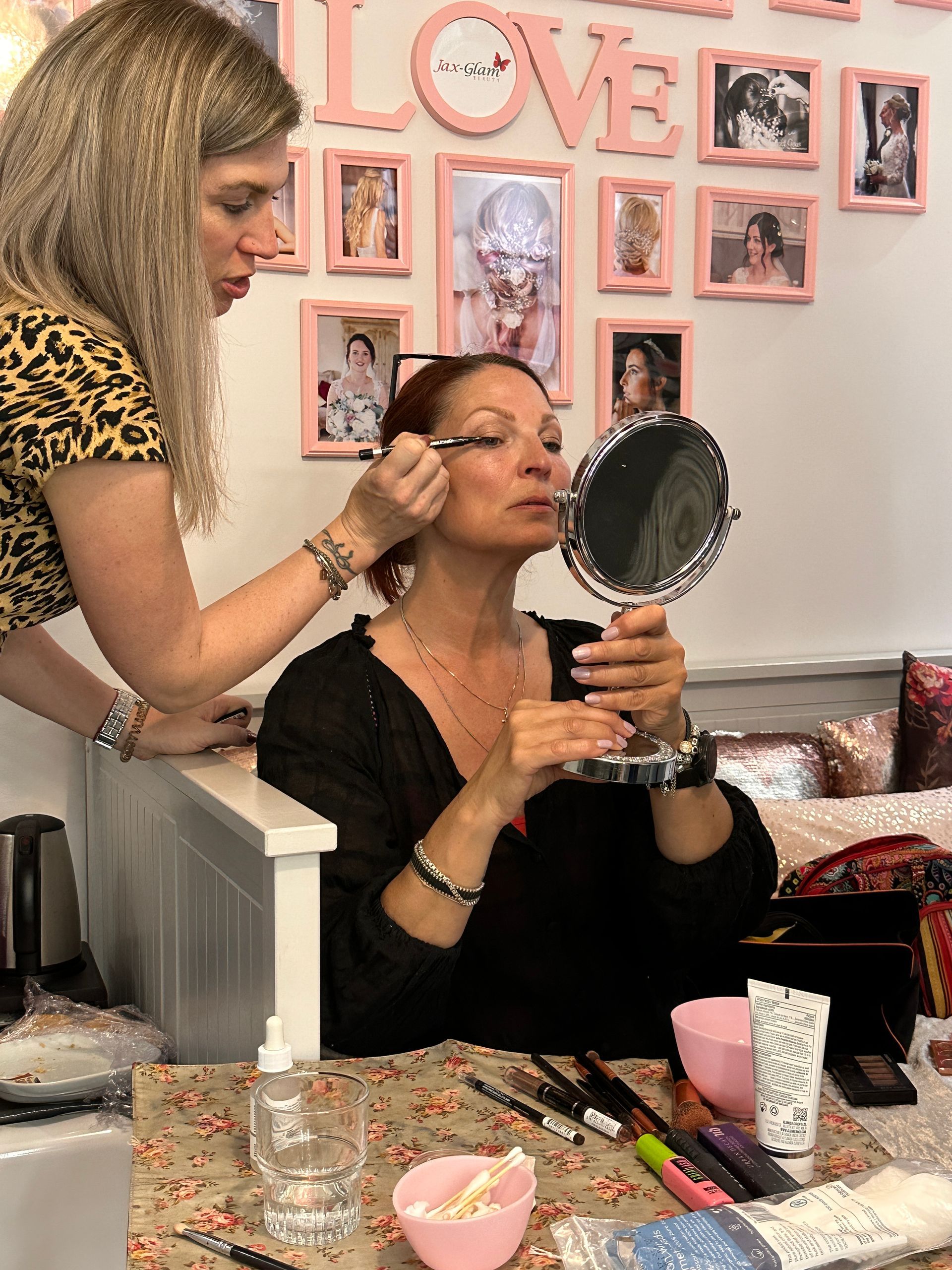 lady applying eye makeup to a client