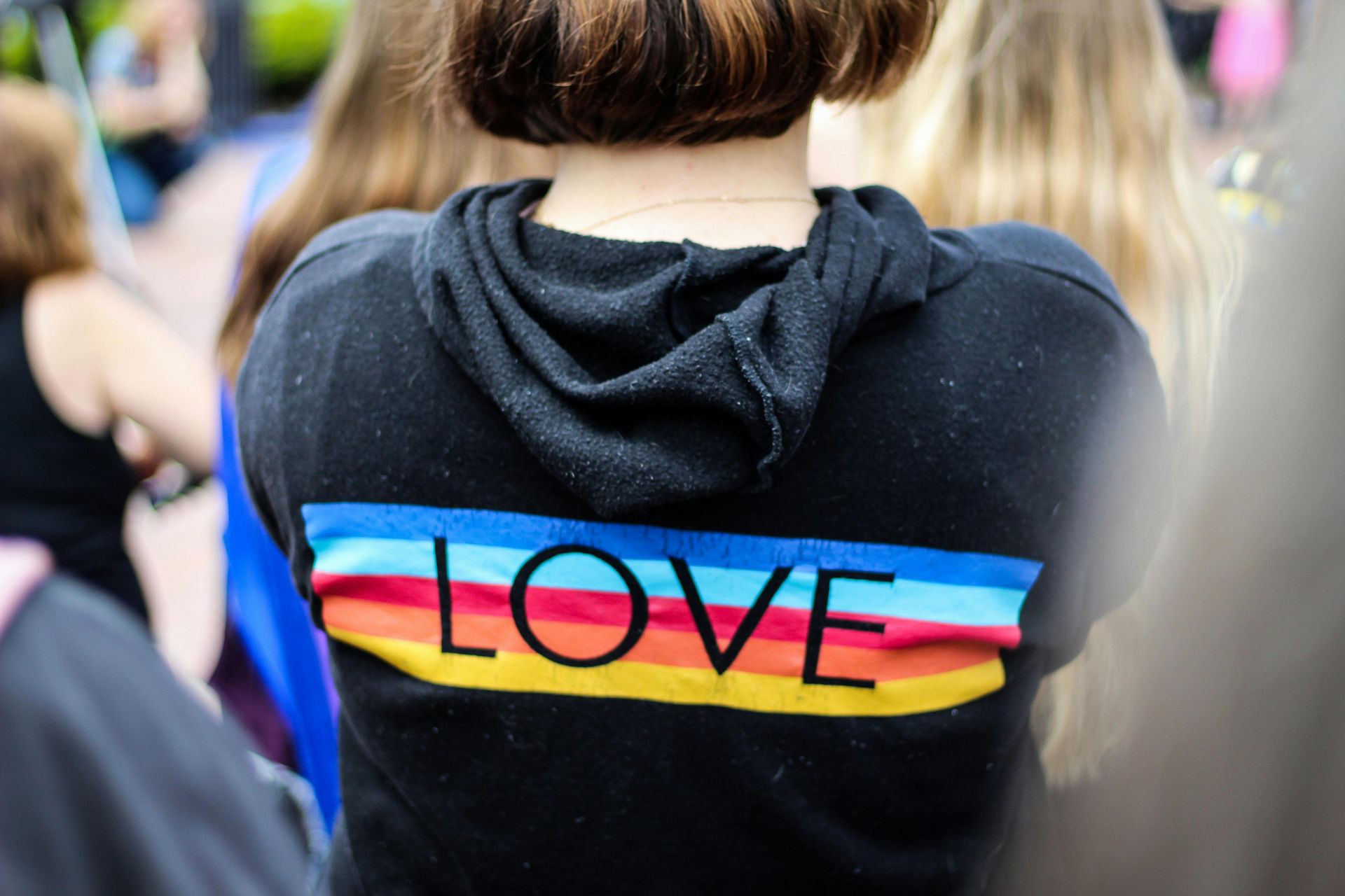 Person wearing a hoodie with rainbow LOVE design, representing an inclusive, welcoming and LGBTQ+ friendly environment