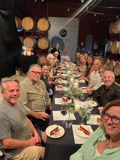 A table with bottles of wine and a plate of food on it