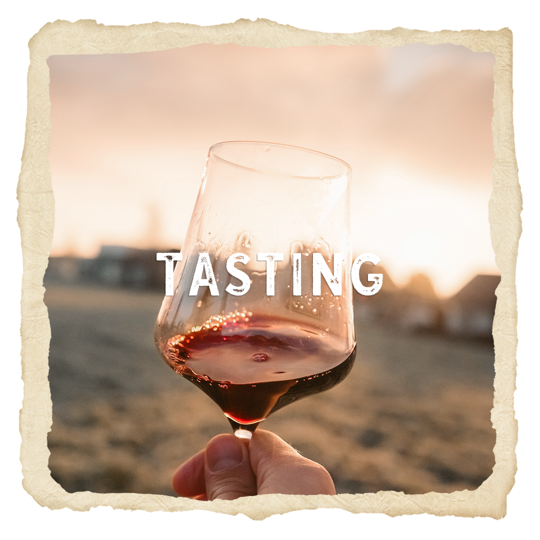 A person is holding a glass of wine with the word tasting written on it