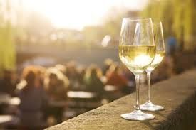 A bottle of wine and a glass of wine are on a table.