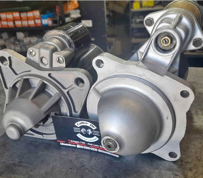 Tres motores de arranque plateados para automóviles expuestos en el mostrador de una tienda.