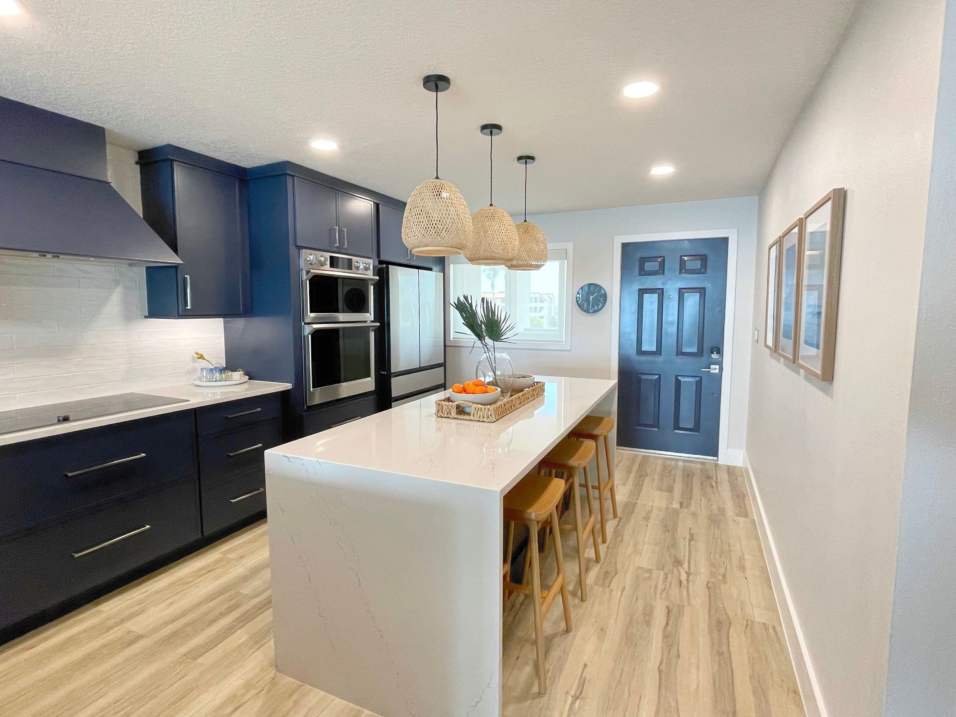 Modern coastal condo kitchen with blue cabinets, white countertops, and beachy decor accents. Modern coastal condo kitchen with blue cabinets, white countertops, and beachy decor accents.