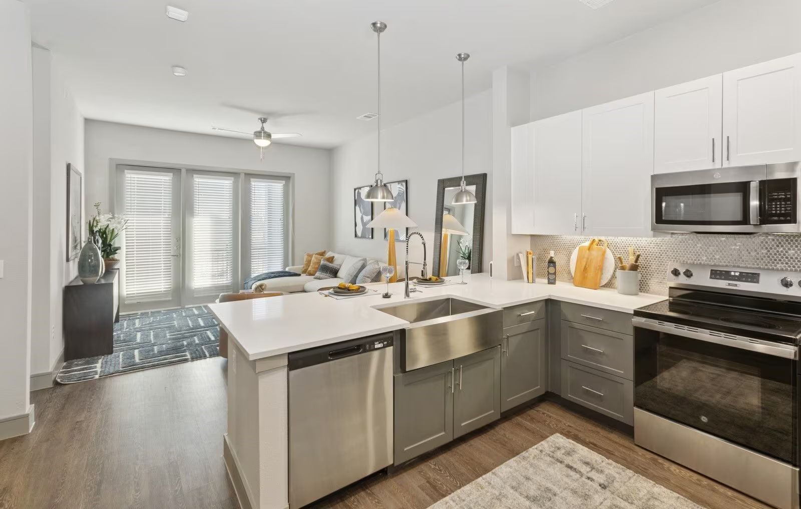 Modern kitchen with white and gray cabinets, stainless steel appliances, and a central island with a sink.
