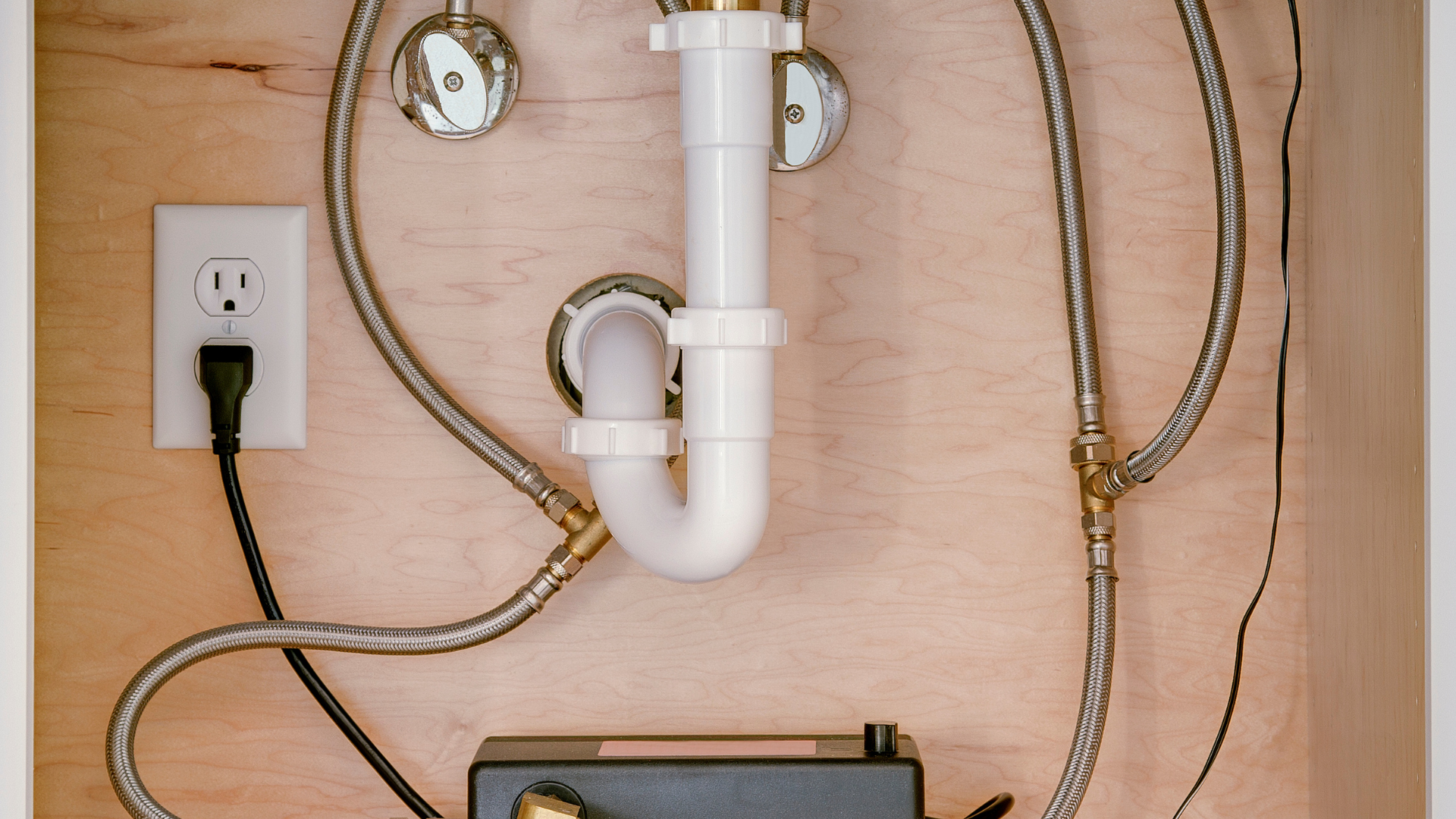 A sink with a hose attached to it and a plug.
