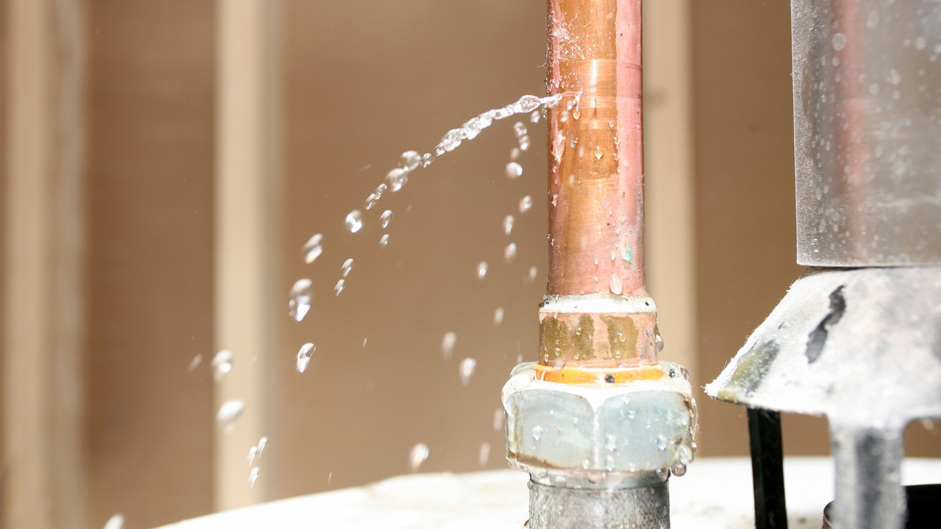 A copper pipe is leaking water from it.