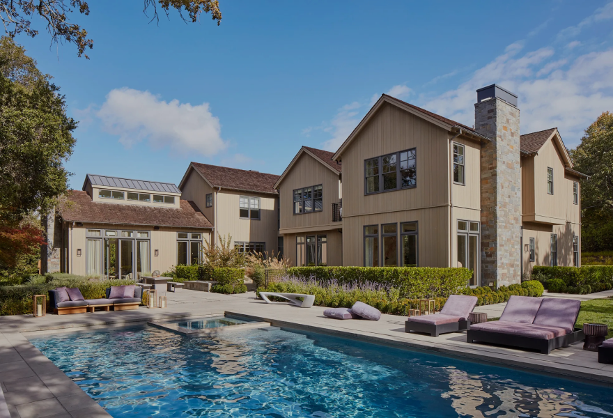 A large house with a swimming pool in front of it.