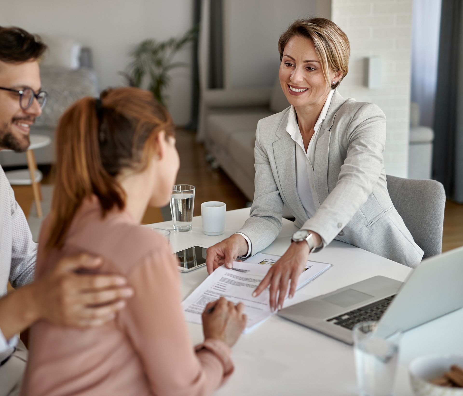 A group of people are sitting around a table looking at blueprints