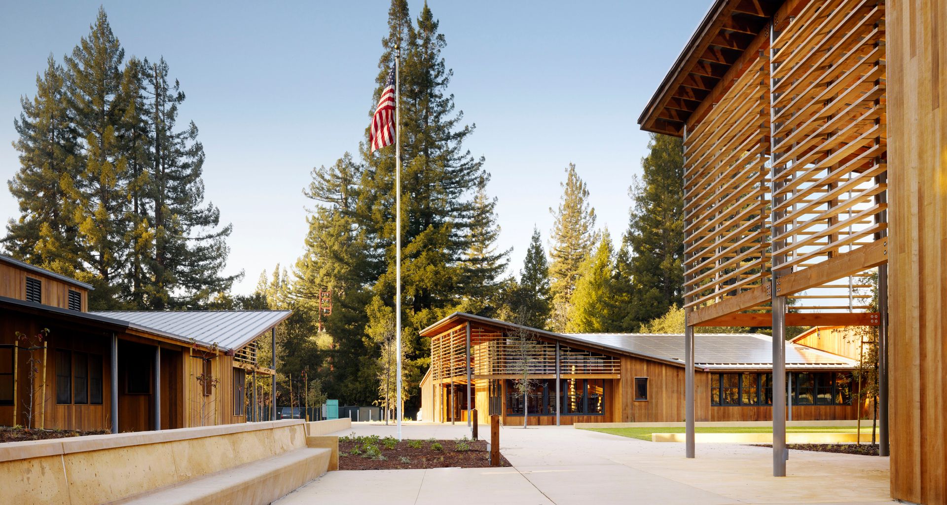 An american flag is flying in front of a wooden building