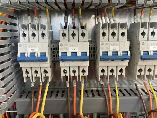 A row of circuit breakers are connected to each other in a electrical box.