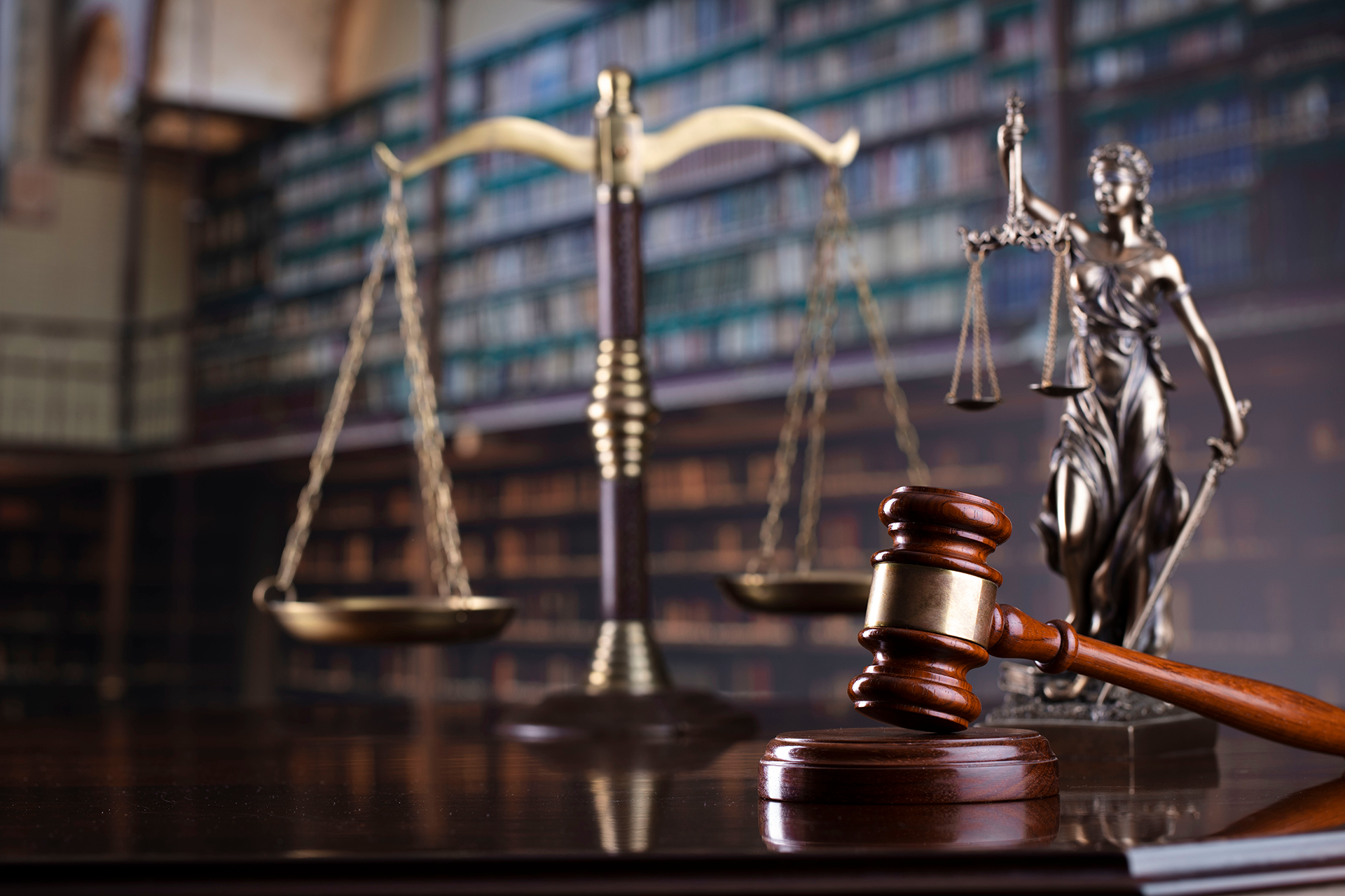 A statue of justice , scales of justice and a judge 's gavel on a table.