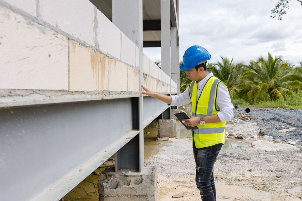 A person is shaking hands with a real estate agent in front of a model house.