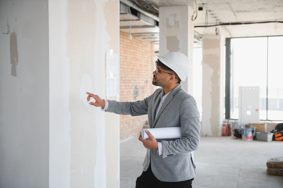 A person is shaking hands with a real estate agent in front of a model house.